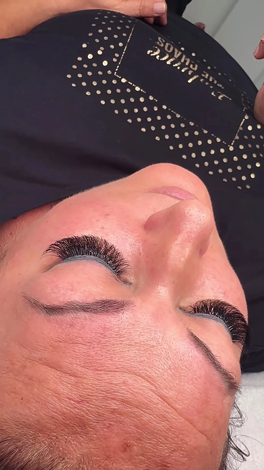 Lash extensions applied, client reclining in profile