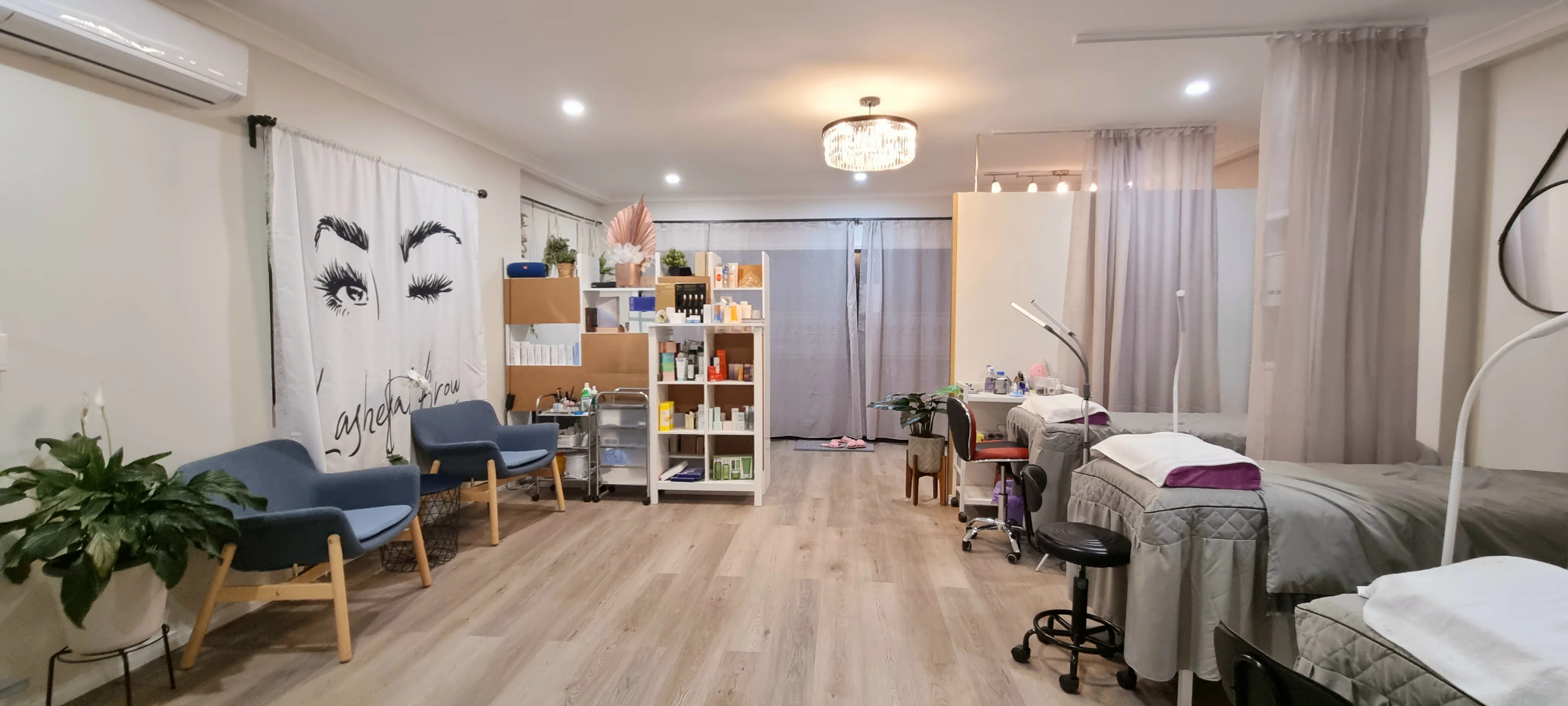 Studio lounge — blue armchairs, retail shelf, Lashes and Brows wall mural